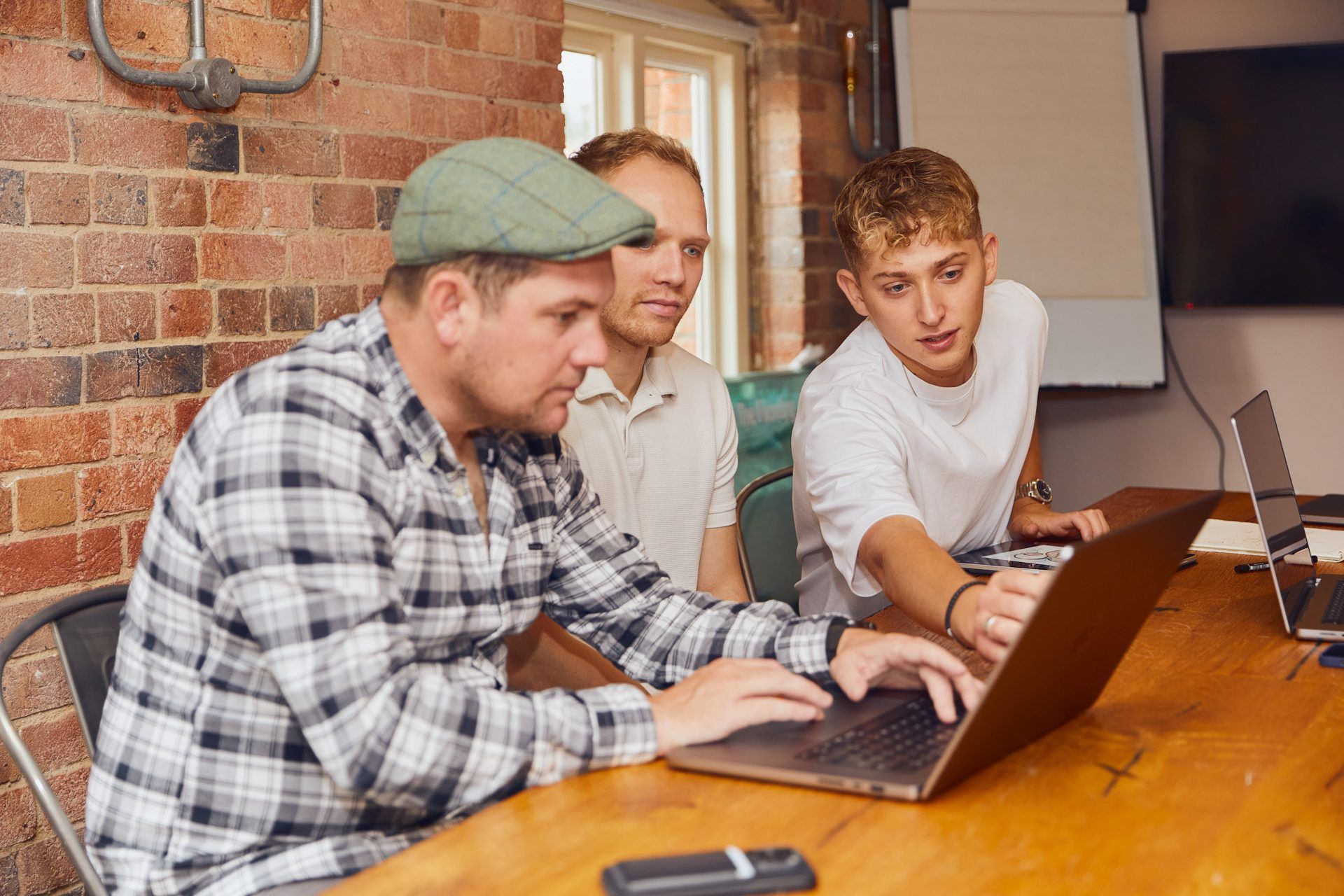 Carl, Toby & Josh sat working behind a laptop.